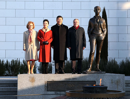 習(xí)近平夫婦在巴赫夫婦陪同下拾階而上，在現(xiàn)代奧林匹克運動發(fā)起人顧拜旦雕像前合影。
